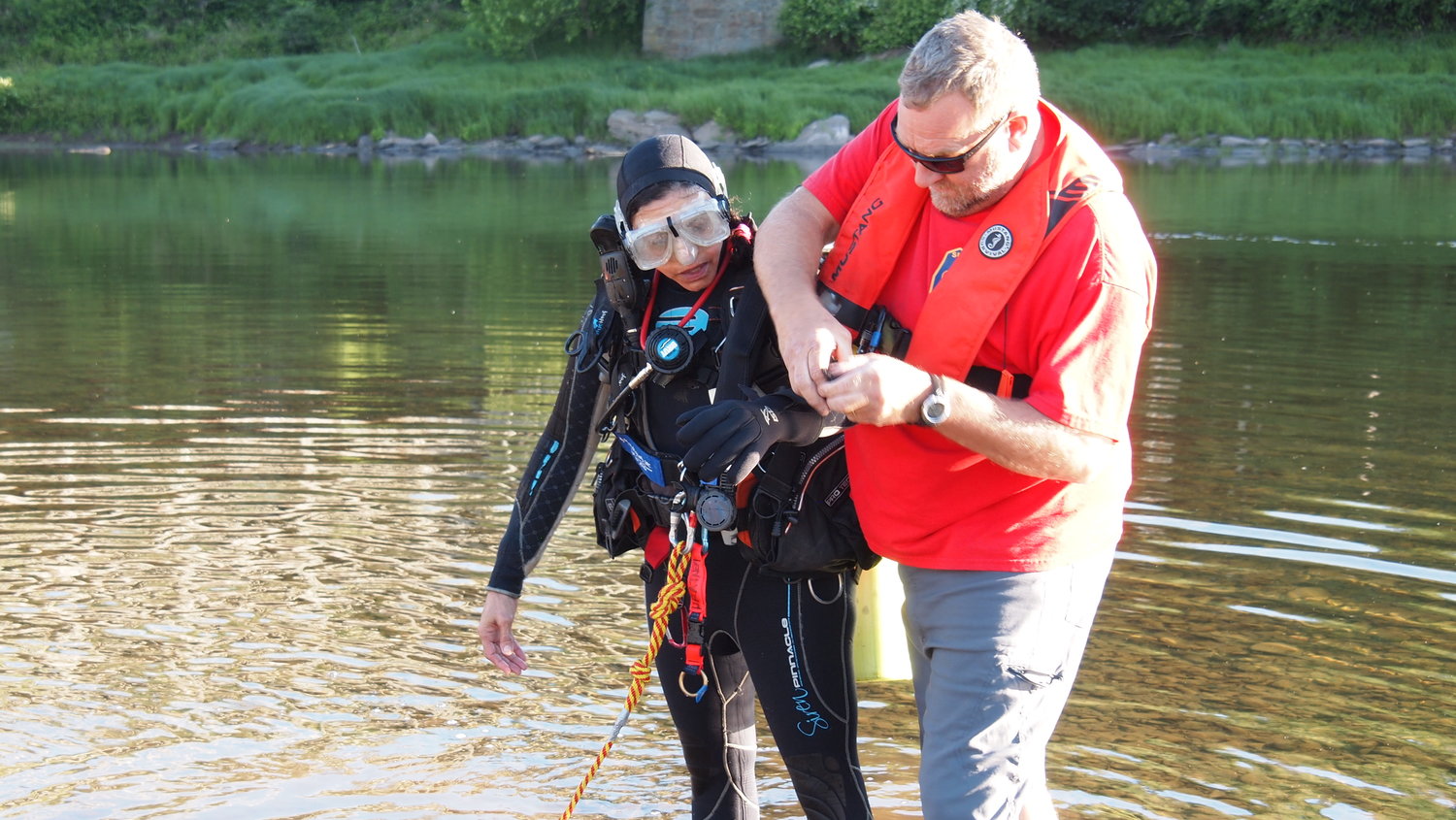 Sharon Doyle, left, a member of the Neversink Fire Department and president of the Sullivan County Dive Team, gets assistance from Joe Ratner, the dive team captain and a member of the Youngsville Fire Department.  The team was at Skinner's Falls in a drill hosted by the Cochecton Ambulance Corp. on June 16.